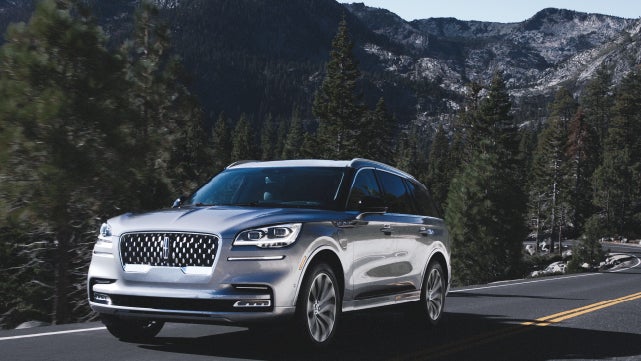 A Lincoln Aviator Grand Touring model is being driven on a mountain road