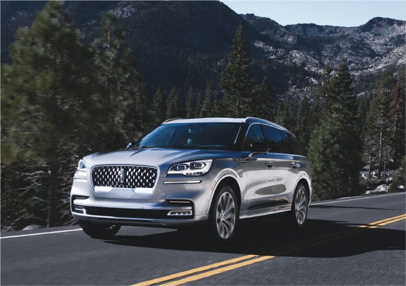 A 2023 Lincoln Aviator® Grand Touring SUV being driven on a winding road to demonstrate the capabilities of all-wheel drive | Capital Lincoln of Wilmington in Wilmington NC