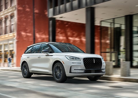 The 2024 Lincoln Corsair® SUV with the Jet Appearance Package and a Pristine White exterior is parked on a city street. | Capital Lincoln of Wilmington in Wilmington NC